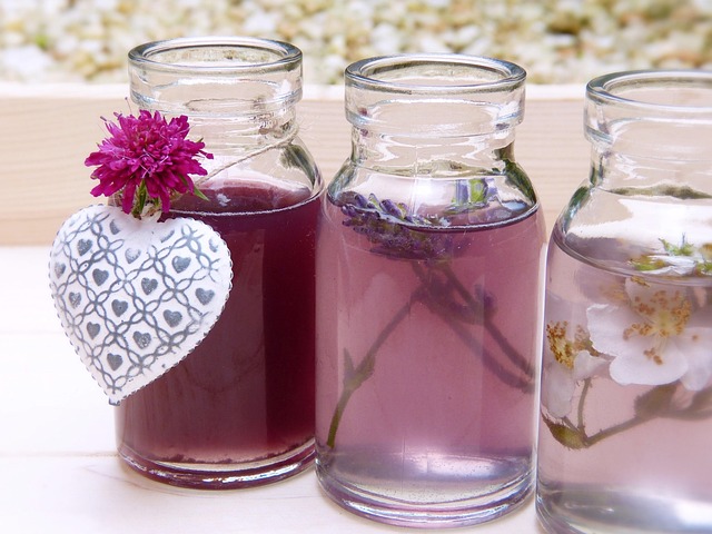 hands blending fragrance oils with glass pipettes and amber bottles on a workbench